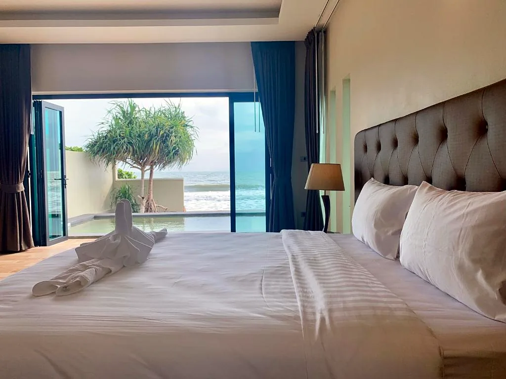 Pool villa bedroom opening to the pool and the sea